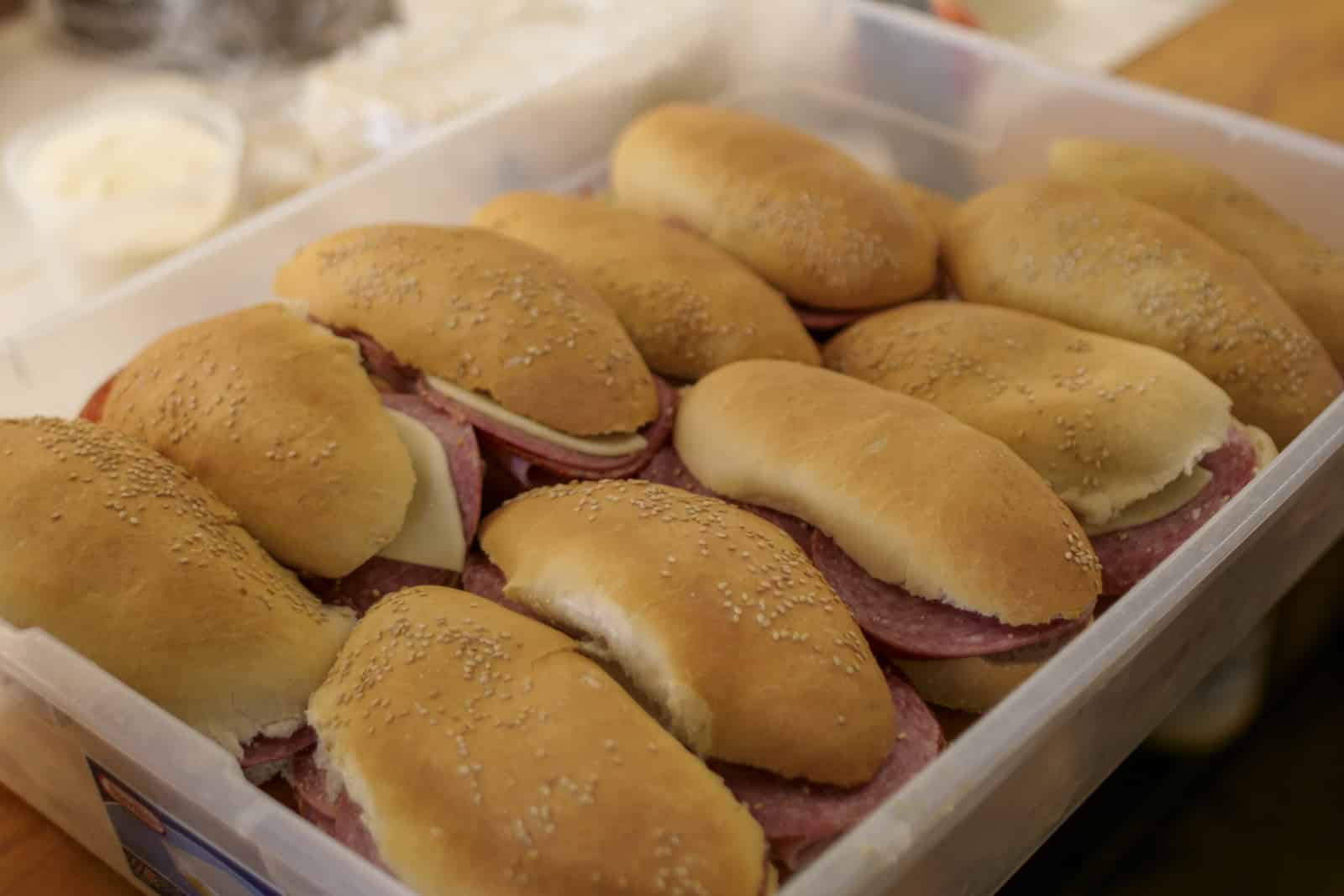 container full of sub sandwiches